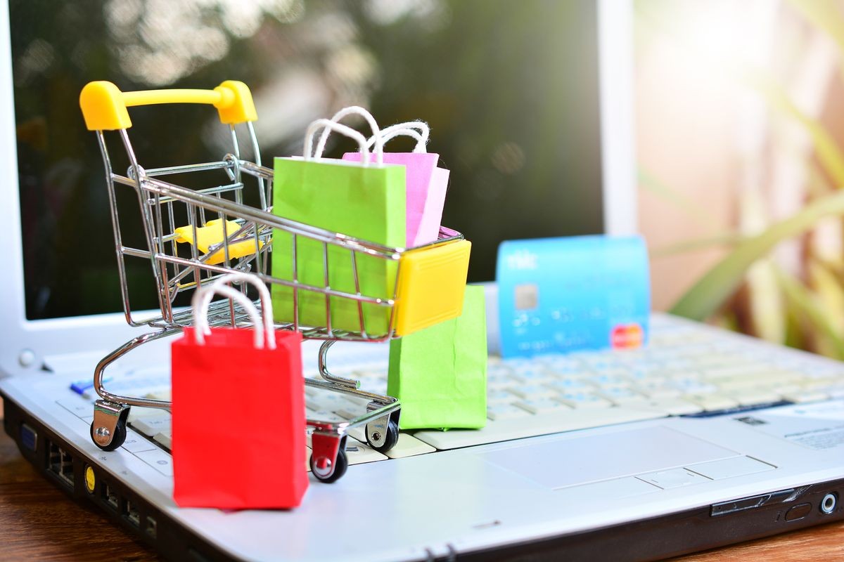 color shopping bags in trolley on computer laptop for concept shopping online and technology business
